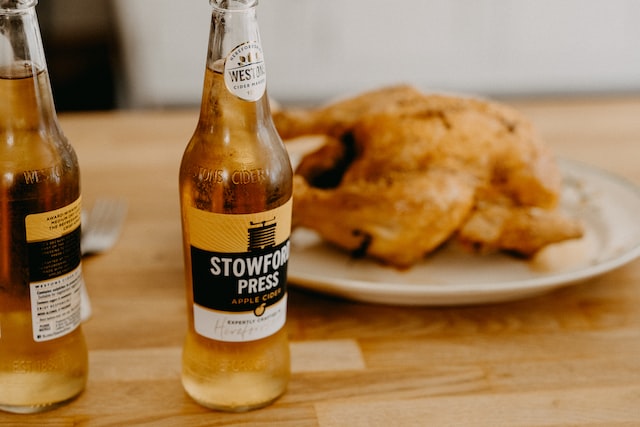 Stowford Press cider on a table with food in the background.