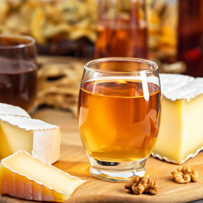 Cider and cheese on a cutting board